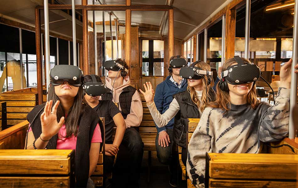 Schulklasse erlebt eine historische VR-Fahrt in einem virtuellen Straßenbahnwagen.