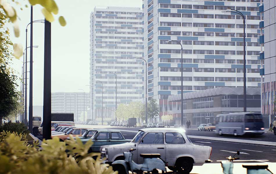 Graue Trabis geparkt vor Plattenbauten der DDR-Zeit.
