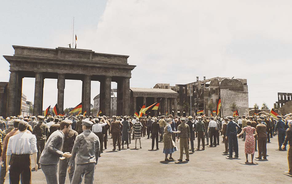 Menschen stehen 1985 mit wehenden Deutschland Flaggen vor dem Brandenburger mit zerstörten Gebäuden im Hintergrund.