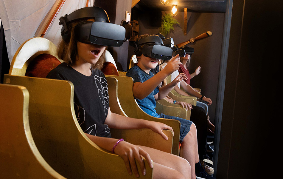 Kinder sitzen mit VR-Brillen in den goldenen Sitzen des Senseums und staunen.
